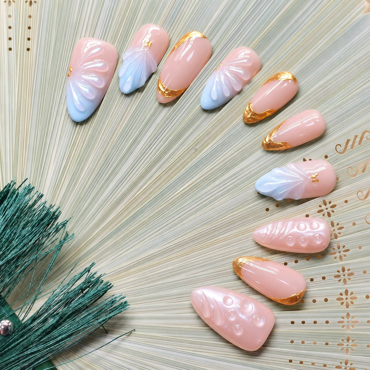 Gilded Azure Fan peach and blue press-on nails with sculpted pearl textures and gold accents — styled product photograph.
