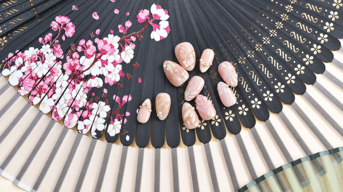 Rose Gold Leaf Veil peach press-on nails with translucent leaves, pearls and fine gold outlines — styled product photograph.