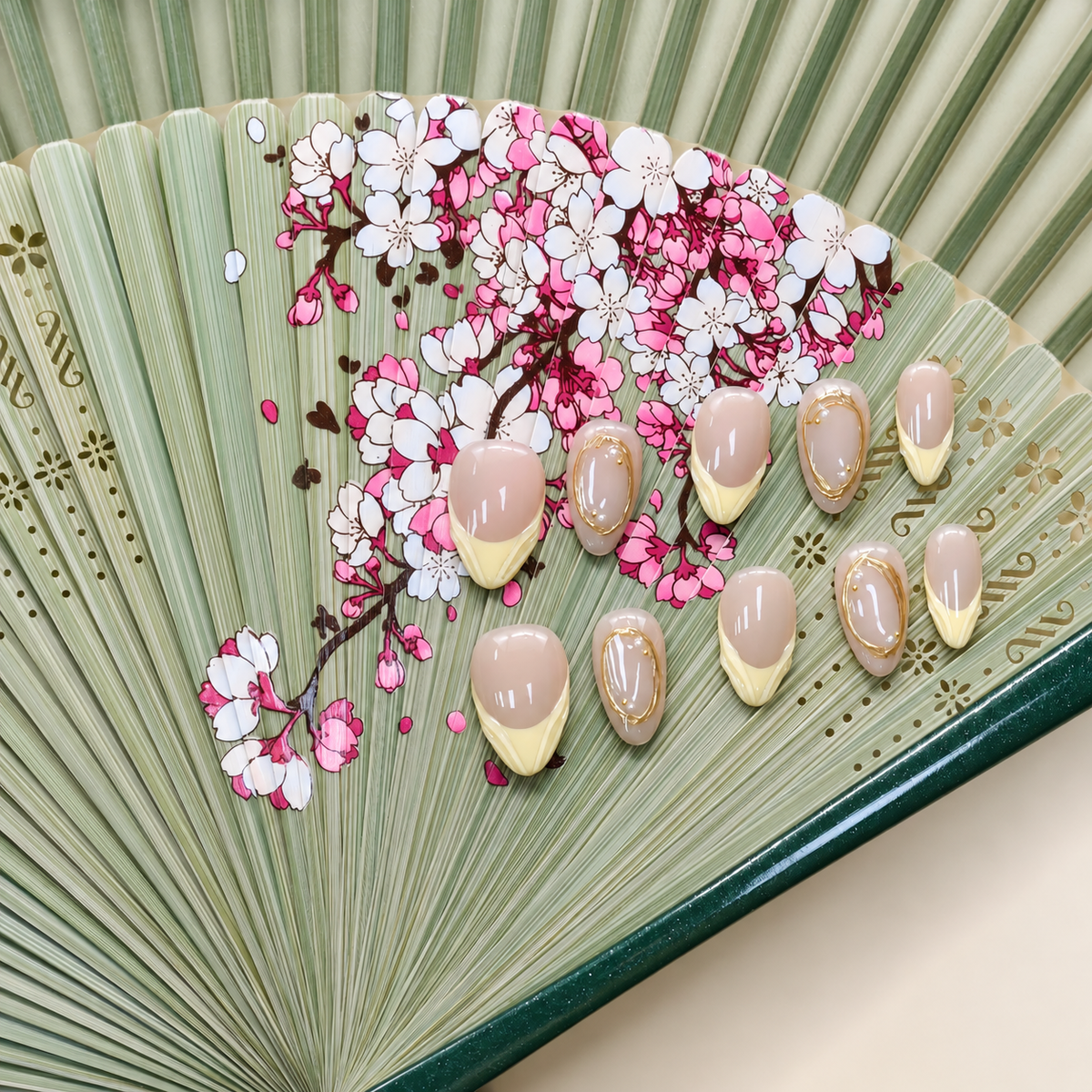 Citrine Silk Veil nude press-on nails with pale yellow French tips and sculpted gold frames — styled product photograph.