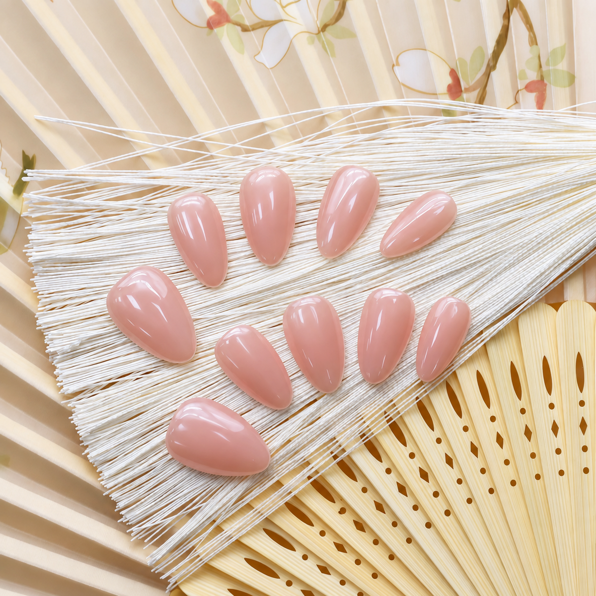 Bare Blush Veil reusable press-on nails in a sheer peach-pink nude with a glossy finish — styled product photograph.
