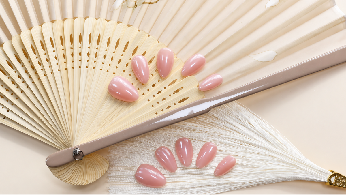 Bare Blush Veil reusable press-on nails in a sheer peach-pink nude with a glossy finish — styled product photograph.