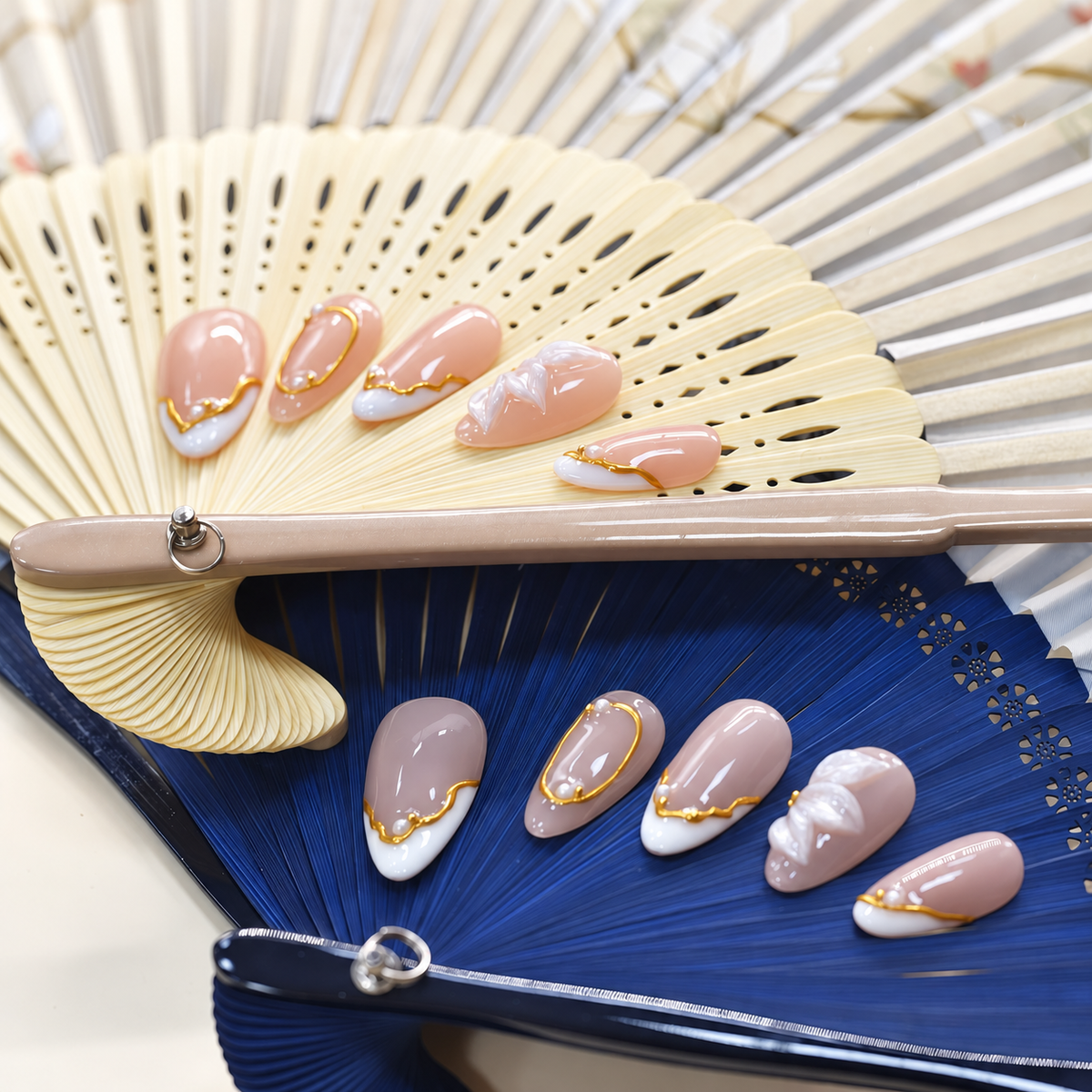 Porcelain Petal Frame blush press-on nails with milky sculpted petals, pearls and gold borders — styled product photograph.
