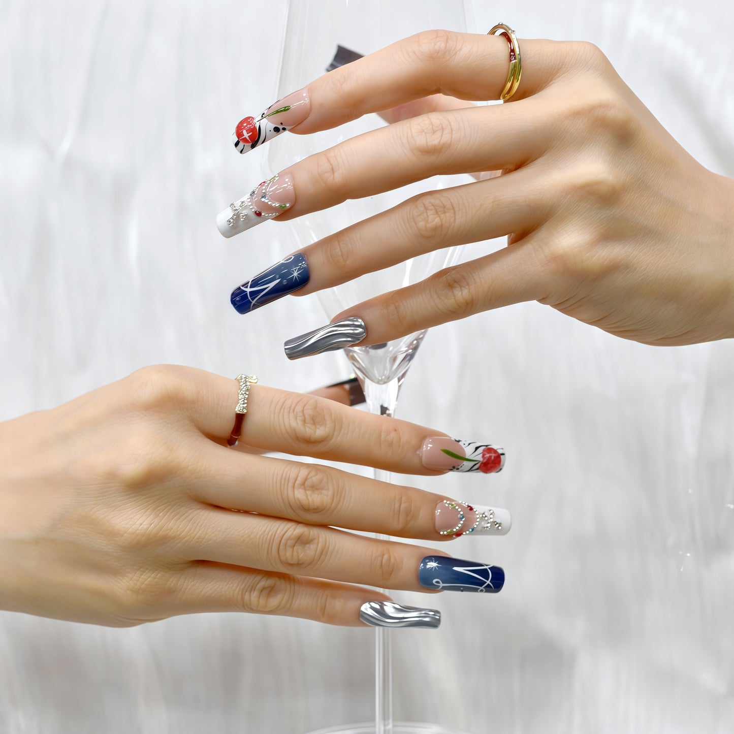 Black and white press on nails with red cherry art, gemstone chains, metallic silver accents, and modern abstract lines – Heart & Heat Collection.